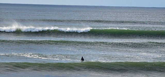 Surfer eyeing up clean waves breaking outside them in front of the shop